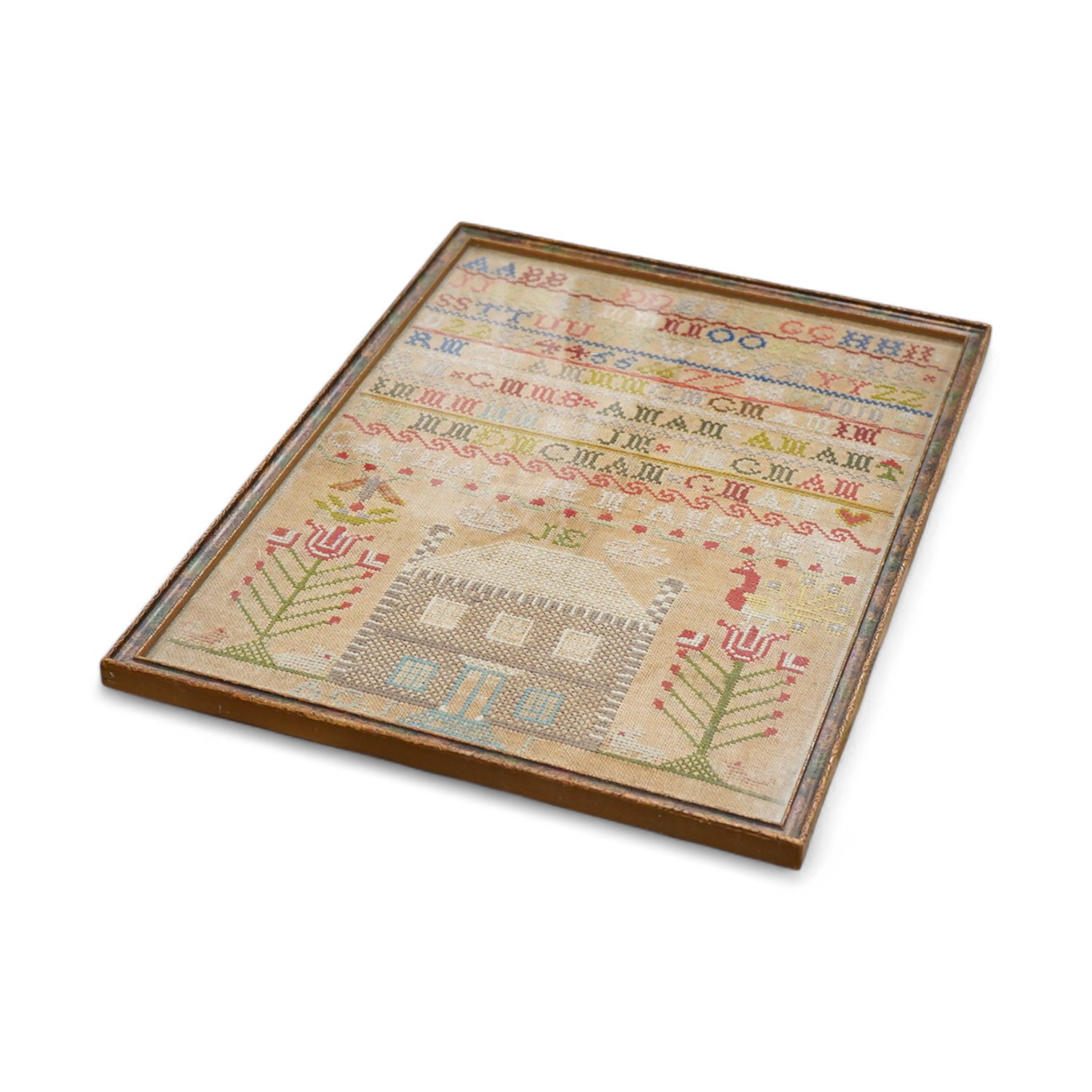 A 19th century alphabet cross stitch sampler, worked with a large house motif - 41cm x 29cm, together with a 19th century unfinished cotton patch worked central panel. Condition - the sampler has some stains but the thre